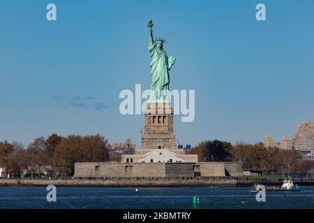 Freiheitsstatue, die während eines wolkenlosen Tages mit Touristen und Besuchern von Liberty Island Manhattan, New York City, USA, von einer Fähre im Meer aus gesehen wird. Die ikonische Kupferstatue erreicht 93m über dem Meer und wurde am 28. Oktober 1886 eingeweiht. Es wurde vom französischen Bildhauer Frédéric Auguste Bartholdi entworfen und sein Metallrahmen wurde von Gustave Eiffel gebaut, die Skulptur war ein Geschenk des französischen Volkes. Heute ist es eine beliebte Touristenattraktion, ein Reiseziel, Wahrzeichen von NYC und den USA, eines der bekanntesten Symbole der Welt. Die Statue ist eine Figur von Stockfoto