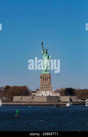 Freiheitsstatue, die während eines wolkenlosen Tages mit Touristen und Besuchern von Liberty Island Manhattan, New York City, USA, von einer Fähre im Meer aus gesehen wird. Die ikonische Kupferstatue erreicht 93m über dem Meer und wurde am 28. Oktober 1886 eingeweiht. Es wurde vom französischen Bildhauer Frédéric Auguste Bartholdi entworfen und sein Metallrahmen wurde von Gustave Eiffel gebaut, die Skulptur war ein Geschenk des französischen Volkes. Heute ist es eine beliebte Touristenattraktion, ein Reiseziel, Wahrzeichen von NYC und den USA, eines der bekanntesten Symbole der Welt. Die Statue ist eine Figur von Stockfoto