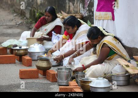 Hindu-Frauen beenden die letzten Vorbereitungen und warten auf das Signal, Pongala am Straßenrand während des Attukal Pongala Mahotsavam Festivals in der Stadt Thiruvananthapuram (Trivandrum), Kerala, Indien, am 19. Februar 2019 zu kochen. Das Attukal Pongala Mahotsavam Festival wird jedes Jahr von Millionen Hindu-Frauen gefeiert. Während dieses Festivals bereiten Frauen Pongala (Reis gekocht mit Jaggery, Ghee, Kokosnuss sowie anderen Zutaten) im Freien in kleinen Töpfen zu, um der Göttin Kannaki zu gefallen. Pongala (was wörtlich bedeutet, überkochen) ist ein rituelles Angebot eines süßen Gerichts, bestehend aus Stockfoto