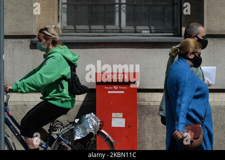In Polen passieren die Menschen einen roten Briefkasten. Am 22. April hat das Ministerium für digitale Angelegenheiten der polnischen Post die PESEL-Registerdaten zur Verfügung gestellt, die für die Vorbereitung der Briefwahl für die Präsidentschaftswahlen im Mai erforderlich sind. Allerdings ist das Wahlregister noch immer erforderlich, aber viele Lokalregierungen weigerten sich, diese Daten der Polnischen Post zu übermitteln. Am Montag, den 27. April 2020, in Krakau, Polen. (Foto von Artur Widak/NurPhoto) Stockfoto
