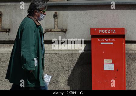 Ein Mann kommt in Polen an einem roten Briefkasten vorbei. Am 22. April hat das Ministerium für digitale Angelegenheiten der polnischen Post die PESEL-Registerdaten zur Verfügung gestellt, die für die Vorbereitung der Briefwahl für die Präsidentschaftswahlen im Mai erforderlich sind. Allerdings ist das Wahlregister noch immer erforderlich, aber viele Lokalregierungen weigerten sich, diese Daten der Polnischen Post zu übermitteln. Am Montag, den 27. April 2020, in Krakau, Polen. (Foto von Artur Widak/NurPhoto) Stockfoto