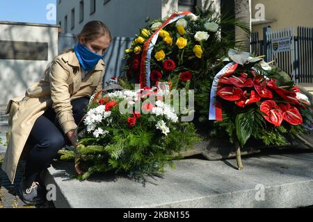 Menschen bringen Blumen, Kerzen und Kränze zum Nowa-Huta-Kreuz-Denkmal, an dem der 60.. Jahrestag der dramatischen Ereignisse um die Entfernung des ursprünglichen Kreuzes begangen wurde. Nowa Huta war eine kommunistische Idee der perfekten sozialistischen Stadt, eine ohne Gott. Doch während der Jahre 1950s baten die Einheimischen offiziell die kommunistische Regierung um eine Baugenehmigung für die Kirche und erhielten 1956 eine positive Antwort. 1957 wurde an der Stelle des geplanten Kirchenbaus ein Kreuz errichtet und geweiht. Doch Anfang 1960 zogen die Behörden die Baugenehmigung zurück, und am 27.. April 1960 wurde ein Team von Arbeitern entlassen Stockfoto