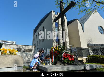 Menschen bringen Blumen, Kerzen und Kränze zum Nowa-Huta-Kreuz-Denkmal, an dem der 60.. Jahrestag der dramatischen Ereignisse um die Entfernung des ursprünglichen Kreuzes begangen wurde. Nowa Huta war eine kommunistische Idee der perfekten sozialistischen Stadt, eine ohne Gott. Doch während der Jahre 1950s baten die Einheimischen offiziell die kommunistische Regierung um eine Baugenehmigung für die Kirche und erhielten 1956 eine positive Antwort. 1957 wurde an der Stelle des geplanten Kirchenbaus ein Kreuz errichtet und geweiht. Doch Anfang 1960 zogen die Behörden die Baugenehmigung zurück, und am 27.. April 1960 wurde ein Team von Arbeitern entlassen Stockfoto