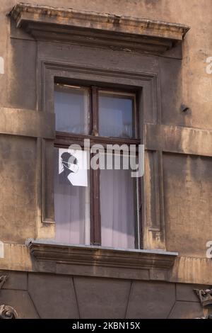 Ein Plakat einer Frau in einer schützenden Gesichtsmaske mit rotem Blitz - ein Zeichen des Frauenstreiks in Polen ist in einem Fenster eines Wohnhauses in einem Zentrum von Krakau während der Covid-19-Pandemie am 27. April 2020 zu sehen. Frauen haben einen Protest, auch Polnische Hölle genannt, gegen eine Abtreibungspolitik begonnen, die derzeit im polnischen parlament diskutiert wird und die Abtreibung auch bei gesundheitlichen Problemen abschafft. (Foto von Dominika Zarzycka/NurPhoto) Stockfoto