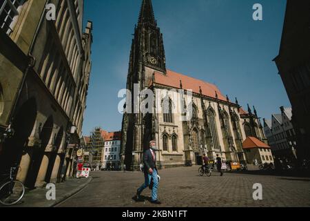 Ein Mann mit Gesichtsmaske geht am domplatz von Münster vorbei, da Deutschland am 27. April 2020 während des Coronavirus-Notfalls zwingend eine Gesichtsmaske in Zug, Bus und Geschäften trägt. (Foto von Ying Tang/NurPhoto) Stockfoto