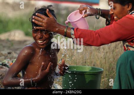 Am 28. April 2020 badet eine Frau in einem Slum in Mumbai, Indien, einen Jungen mit Wasser. Indien befindet sich weiterhin im landesweiten Sperrgebiet, um die Ausbreitung der Coronavirus-Pandemie (COVID-19) zu kontrollieren. (Foto von Himanshu Bhatt/NurPhoto) Stockfoto