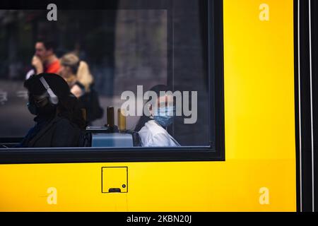 Am 28. April 2020 reisen Menschen mit Schutzmaske in den öffentlichen Verkehrsmitteln in Berlin. Seit gestern ist es Pflicht, eine Maske zu tragen, wenn man mit Metro, Straßenbahnen und Bussen unterwegs ist. Ab morgen wird das Tragen einer Maske auch in Geschäften und Geschäften Pflicht sein. (Foto von Emmanuele Contini/NurPhoto) Stockfoto