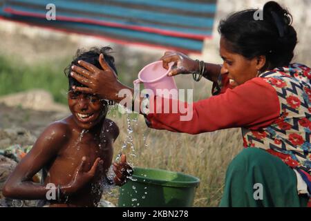 Am 28. April 2020 badet eine Frau in einem Slum in Mumbai, Indien, einen Jungen mit Wasser. Indien befindet sich weiterhin im landesweiten Sperrgebiet, um die Ausbreitung der Coronavirus-Pandemie (COVID-19) zu kontrollieren. (Foto von Himanshu Bhatt/NurPhoto) Stockfoto