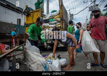 Die Bewohner bringen am 29. April 2020 ihren Hausmüll für Müllsammler in Quezon City, Philippinen, zur Abholung. Auch als Frontliner gefeiert, arbeiten Müllsammler trotz der gesundheitlichen Risiken und des Mangels an persönlicher Schutzausrüstung (PSA) weiterhin eng mit unterschiedlichen Abfällen in Kontakt. Auf den Philippinen gab es bisher insgesamt 8.212 COVID-19-Fälle, 558 Todesfälle und 1.023 Genesungen.(Foto: Lisa Marie David/NurPhoto) Stockfoto