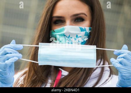 Eine Gastgeberin hält eine Einweg-OP-Gesichtsmaske, die von der Energieholding Tauron Polska Energia S.A. während der Ausbreitung des Coronavirus kostenlos verteilt wurde. Krakau, Polen, am 30. April 2020. Die Regel, Nase und Mund an öffentlichen Orten mit Gesichtsmasken, Schnitzeln oder Taschentüchern zu bedecken, trat ab April 16. in Kraft. Die Verordnung gilt nicht für Kinder bis zum Alter von zwei Jahren und Menschen, die aufgrund von Atembeschwerden nicht in der Lage sind, ihren Mund oder ihre Nase zu bedecken. (Foto von Beata Zawrzel/NurPhoto) Stockfoto