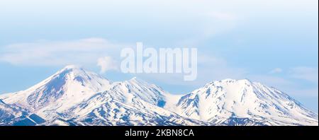 Über der Stadt Petropawlowsk-Kamtschatsky auf der Halbinsel Kamtschatka thront der Avatschinski-Vulkan Stockfoto