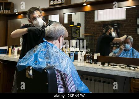 Ein Mann bekommt einen Haarschnitt bei einem Friseur, als das Land am 4. Mai 2020 in Madrid, Spanien, offiziell die erste von vier Phasen der Deeskalation einleitet. Da Spanien die akute Phase der Krankheit verblassen sieht, beginnt am Montag offiziell die erste von vier Phasen der Deeskalation. Einige Unternehmen wie Friseure, Zahnärzte oder Eisenwarengeschäfte beginnen zu operieren, aber Kunden werden nur nach Vereinbarung zugelassen. (Foto von Oscar Gonzalez/NurPhoto) Stockfoto