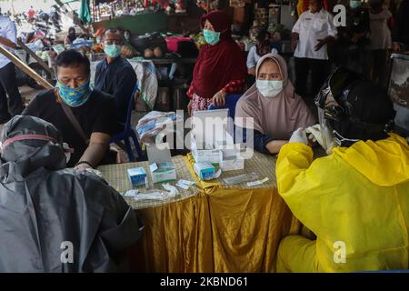 Medizinisches Personal mit persönlicher Schutzausrüstung nimmt am 6. Mai 2020 Blutproben während des Covid-19-Schnelltests an traditionelle Markthändler in Sidoarjo, Ost-Java. Die indonesische Regierung führt weiterhin einen Covid-19-Schnelltest an Bewohnern durch, um sofort von der Covid-19-Pandemie frei zu sein. (Foto von Suryanto Putramudji/NurPhoto) Stockfoto