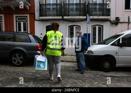 Am 6. Mai 2020 führen Arbeiter mit Schutzmasken die Verteilung und Lieferung von Lebensmitteln an die Menschen in der Stadt Lissabon, Portugal, durch. Trotz der Aufhebung der Notfallmaßnahmen, die den freien Transit einschränkten, und der Verhängung einer obligatorischen Quarantäne führen die Institutionen der portugiesischen Regierung weiterhin ihre Projekte zur Unterstützung der Bürger angesichts des Vordringens des COVID-19 durch. Der Gemeinschaftsrat von Estrela hat Maßnahmen zur Eindämmung des SARS-CoV-2-Virus (COVID-19) verabschiedet, zu denen auch die Sozialhilfe für die Gemeinschaft gehört. SOS Stockfoto