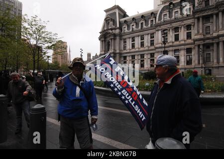 Ein Unterstützer von US-Präsident Donald Trump schwingt eine Flagge, als sich Menschen versammeln, um gegen die am 8. Mai 2020 in Philadelphia, PA, noch immer in Kraft getretenden Aufenthaltsbefehlen zu protestieren. (Foto von Cory Clark/NurPhoto) Stockfoto