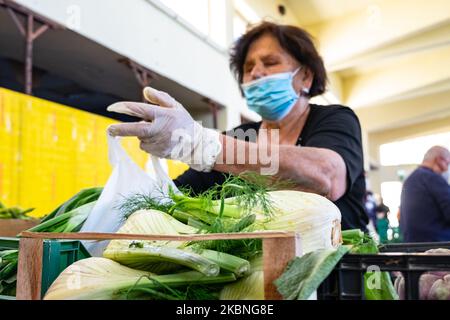 Ein Verkäufer, der Schutzmasken und Handschuhe trägt, bedient einen Kunden bei einer lokalen Marktöffnung für lokale Landwirte Lanciano, Italien, am 9. Mai 2020 während des Phase 2-Coronavirus-Notfalls. (Foto von Federica Roselli/NurPhoto) Stockfoto