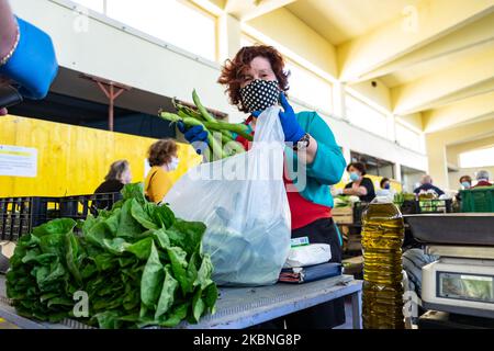 Ein Verkäufer, der Schutzmasken und Handschuhe trägt, bedient einen Kunden bei einer lokalen Marktöffnung für lokale Landwirte Lanciano, Italien, am 9. Mai 2020 während des Phase 2-Coronavirus-Notfalls. (Foto von Federica Roselli/NurPhoto) Stockfoto