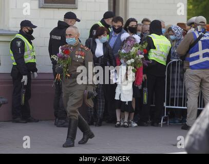 Am 09. Mai 2020 tragen Menschen Blumen zum Denkmal des ewigen Ruhms auf dem Grab des unbekannten Soldaten, während der Feier des Sieges inmitten des Covid-19-Coronavirus-Ausbruchs in Kiew, Ukraine. Die Ukrainer gedenken des 75.. Jahrestages des Sieges über Nazi-Deutschland im Zweiten Weltkrieg. (Foto von STR/NurPhoto) Stockfoto