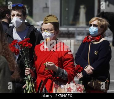 Am 09. Mai 2020 tragen Menschen Blumen zum Denkmal des ewigen Ruhms auf dem Grab des unbekannten Soldaten, während der Feier des Sieges inmitten des Covid-19-Coronavirus-Ausbruchs in Kiew, Ukraine. Die Ukrainer gedenken des 75.. Jahrestages des Sieges über Nazi-Deutschland im Zweiten Weltkrieg. (Foto von STR/NurPhoto) Stockfoto