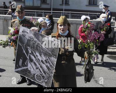 Am 09. Mai 2020 tragen Menschen Blumen zum Denkmal des ewigen Ruhms auf dem Grab des unbekannten Soldaten, während der Feier des Sieges inmitten des Covid-19-Coronavirus-Ausbruchs in Kiew, Ukraine. Die Ukrainer gedenken des 75.. Jahrestages des Sieges über Nazi-Deutschland im Zweiten Weltkrieg. (Foto von STR/NurPhoto) Stockfoto