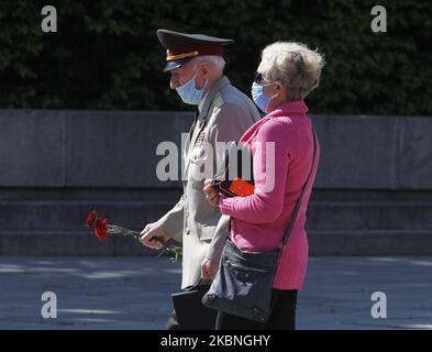 Am 09. Mai 2020 tragen Menschen Blumen zum Denkmal des ewigen Ruhms auf dem Grab des unbekannten Soldaten, während der Feier des Sieges inmitten des Covid-19-Coronavirus-Ausbruchs in Kiew, Ukraine. Die Ukrainer gedenken des 75.. Jahrestages des Sieges über Nazi-Deutschland im Zweiten Weltkrieg. (Foto von STR/NurPhoto) Stockfoto