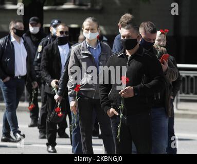 Während der Feier des Sieges am 09. Mai 2020, inmitten des Covid-19-Coronavirus-Ausbruchs in Kiew, Ukraine, warten Menschen in der Schlange darauf, Blumen zum Denkmal des ewigen Ruhms auf dem Grab des unbekannten Soldaten zu tragen. Die Ukrainer gedenken des 75.. Jahrestages des Sieges über Nazi-Deutschland im Zweiten Weltkrieg. (Foto von STR/NurPhoto) Stockfoto