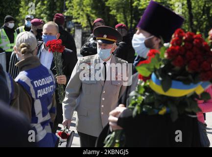 Am 09. Mai 2020 tragen Menschen Blumen zum Denkmal des ewigen Ruhms auf dem Grab des unbekannten Soldaten, während der Feier des Sieges inmitten des Covid-19-Coronavirus-Ausbruchs in Kiew, Ukraine. Die Ukrainer gedenken des 75.. Jahrestages des Sieges über Nazi-Deutschland im Zweiten Weltkrieg. (Foto von STR/NurPhoto) Stockfoto