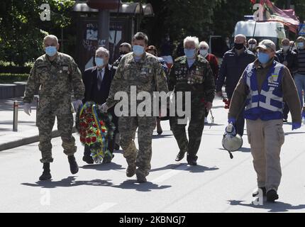 Am 09. Mai 2020 tragen Menschen Blumen zum Denkmal des ewigen Ruhms auf dem Grab des unbekannten Soldaten, während der Feier des Sieges inmitten des Covid-19-Coronavirus-Ausbruchs in Kiew, Ukraine. Die Ukrainer gedenken des 75.. Jahrestages des Sieges über Nazi-Deutschland im Zweiten Weltkrieg. (Foto von STR/NurPhoto) Stockfoto