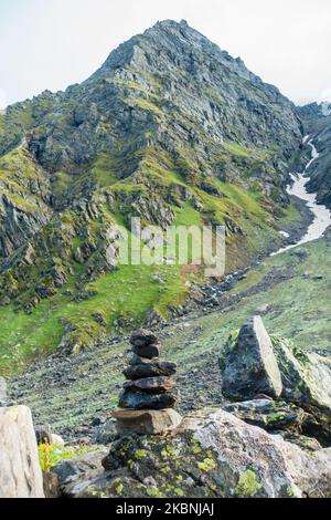 Shiva Linga aus Felsen, ein Symbol von Lord Shiva in der Hindu-Mythologie mit Gletscherbergen im Hintergrund. Shrikhand Mahadev Kailash Yatra in der Stockfoto