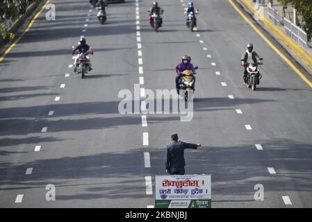 Ein nepalesischer Polizeibeamter hält Fahrzeuge an, um Fahrpässe zu überprüfen, da der Fahrzeugstrom in Kathmandu zugenommen hat, da die Regierung am Sonntag, dem 10. Mai 2020, während der vollständigen Staatssperre in Kathmandu, Nepal, Banken, Finanzinstitute, Agrarsektoren und Industrien geöffnet hat. (Foto von Narayan Maharjan/NurPhoto) Stockfoto