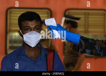 Ein Sri-lankischer Soldat führt eine Temperaturkontrolle an einem Pendler durch, der zur Arbeit in Colombo, Sri Lanka, eintraf. 11 Mai 2020. Tausende von Sri-lankischen soldiersÂ wurden von der Regierung Sri Lankas eingesetzt, seit im März die Sperrstunde im ganzen Land nach assistÂ verhängt wurde, um die Ausbreitung des Covid-19-Virus in Sri Lanka zu minimieren. Â die Regierung Sri Lankas unter der Leitung von Präsident Gotabaya RajapaksaÂ hat den Großteil des Staates und wieder aufgenommen Dienstleistungen des privaten Sektors am Montag (11) in ColomboÂ inmitten der Ausgangssperre . Laut dem Lagebericht Covid-19 (11. Mai 2020) der Epidemiologischen Abteilung ofÂ in Sri Lanka Stockfoto