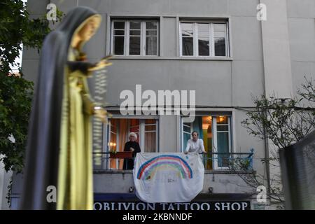 Menschen aus Fenstern und Balkonen von Gebäuden beobachten den Durchgang des Bildes der Jungfrau Maria durch die verschiedenen Straßen der Stadt Lissabon, 12. Mai 2020. Auf Vorschlag der portugiesischen Regierung, eine soziale Distanz zu wahren, um die Ausbreitung von COVID-19 zu vermeiden, wurden viele soziale Aktivitäten gestrichen und andere in ihrer Programmplanung geändert, Das ist der Fall der religiösen Feierlichkeiten zu Ehren der Jungfrau von Fatima, deren zentraler Tag der 13. Mai ist, und dass die Behörden der katholischen Kirche beschlossen haben, sie als Pilgerfahrt "ohne Pilger" zu feiern, die aus einem besteht Stockfoto