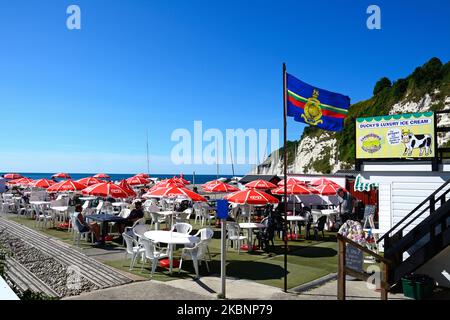 Cafe am Strand mit Lyme Bay Strand und Klippen nach hinten, Bier, Devon, Großbritannien, Europa. Stockfoto