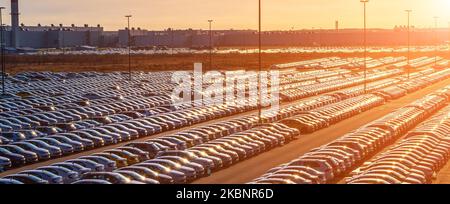 Volkswagen, Russland, Kaluga - 1. NOVEMBER 2022: Neue Autos parkten in einem Distributionszentrum bei Sonnenuntergang, einer Autofabrik. Parken im Freien mit Sonnenbaden Stockfoto