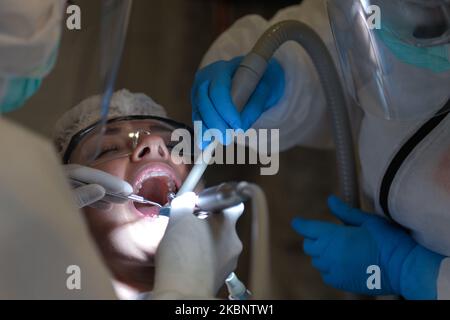 Eine Zahnärztin und ihre Assistentin mit PSA betreuen eine Patientin im Dentima Specialized Dental Center in Krakau. Am Freitag, den 15. Mai 2020, in Krakau, Polen. (Foto von Artur Widak/NurPhoto) Stockfoto