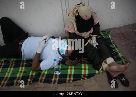 Ein Patient legt sich allein mit seiner Familie auf den Boden, als sie am Dienstag, den Mai, vor einem Krankenhaus auf den Covid-19-Test in Dhaka, Bangladesch warten. 16, 2020. (Foto von Syed Mahamudur Rahman/NurPhoto) Stockfoto