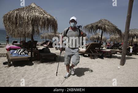 Die Menschen genießen den Strand an den südlichen Vororten von Athen, am ersten Tag der offiziellen Wiedereröffnung der Strände für die Öffentlichkeit, in Athen am 16. Mai 2020. Rund 515 Strände werden ab Mai 16 wieder geöffnet, wobei strenge soziale Distanzierungsmaßnahmen zur Bekämpfung der Ausbreitung der COVID-19-Pandemie ergriffen werden. (Foto von Panayotis Tzamaros/NurPhoto) Stockfoto