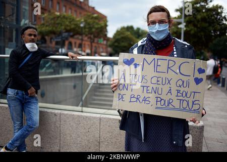 Ein Protestler hält am 16. 2020. Mai in Toulouse, Frankreich, ein Plakat mit der Aufschrift „Danke an die, die während der Pandemie für uns alle festgehalten haben“. Sie wurde wegen „illegaler Sammlung“ mit einer Geldstrafe von 135EUR bestraft. Als die Sperre in Frankreich am 11.. Mai zu Ende ging, riefen die Demonstranten der Gelbwesten zu einem neuen Protest für den 16.. Mai auf. Das Sammeln der Gelbwesten wurde vom Präfekten von Haute-Garonne verboten. Yellow Vests versuchte sich zu versammeln, aber eine starke Polizeipräsenz, Identitätskontrollen, Verhaftungen und Geldstrafen blockierten sie. Die Polizei schickte auch eine Wasserkanone. Fast jeder trägt eine Schutzmaske, wenn die CORONAVIRUS-Pandemie SRAS-CoV-2 ausbricht Stockfoto