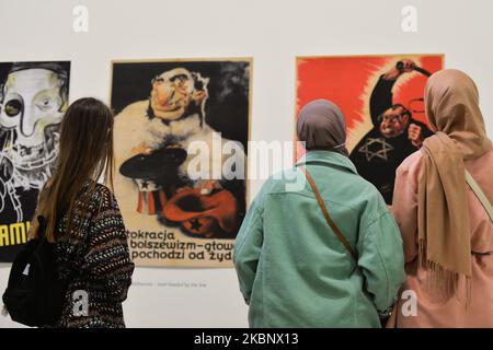 Die Besucher sehen sich antisemitische Nazi-Plakate an, die an Polen gerichtet sind, die Teil des Zweiten Weltkriegs – Drama, Symbol, Trauma-Ausstellung im Museum für zeitgenössische Kunst MOCAK in Krakau sind. Am 16. Mai 2020 in Krakau, Polen. (Foto von Artur Widak/NurPhoto) Stockfoto