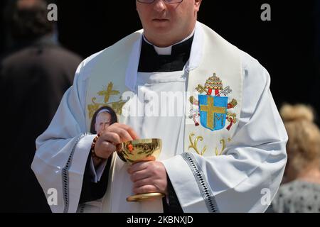 Während der Messe, die der Erzbischof von Krakau, Marek Jedraszewski, vor der Basilika zur Darstellung der seligen Jungfrau Maria in Wadowice, dem Geburtsort von Karol Wojtyla, am Vorabend des 100.. Geburtstages des Papstes, führt, verteilt ein Priester eine heilige Kommunion. Am Sonntag, den 17. Mai 2020, in Wadowice, Woiwodschaft Kleinpolen, Polen. (Foto von Artur Widak/NurPhoto) Stockfoto