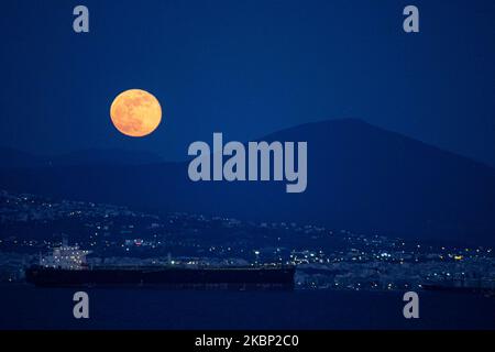 Der schillernde Super Flower Moon vom 2020. Mai, der am 7. Mai 2020 von Kalochori aus über die Ägäis und Thessaloniki Stadt in Griechenland aufsteigt. Der Aufstieg der letzten der letzte Supermond von 2020 erscheint über den Hügeln der Stadt Thessaloniki, leuchtet hell in der griechischen mediterranen Himmel und reflektiert auf dem Meer Beleuchtung der dunklen Nacht. (Foto von Nicolas Economou/NurPhoto) Stockfoto