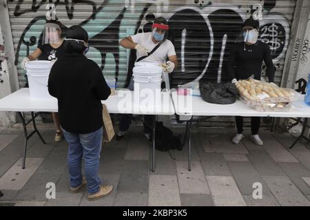 Junge Freiwillige lieferten am 20. Mai 2020 in der Nähe des Insurgente-Kreises in Mexiko-Stadt, Mexiko, Nahrung zur Unterstützung der Bevölkerung auf der Straße und der Menschen mit begrenzten Ressourcen aufgrund der Gesundheitsnotlage in Covid-19 in Mexiko. Mit Masken und Handschuhen besorgten die Jugendlichen eine große Gruppe von Menschen, die sich anstellten, um ihr Gericht zu erhalten: Huhn in grüner Sauce mit Kartoffeln, Pasta und Brot. Das gesamte Essen ist kostenlos. (Foto von Gerardo Vieyra/NurPhoto) Stockfoto