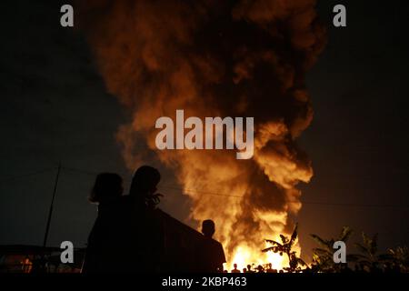 Die Bewohner beobachten die Flammen, wie am 21. Mai 2020 in der Kunststoff-Recycling-Fabrik in Bekasi, Provinz West-Java, Feuer ausbrach. Augenzeugenberichten zufolge kam es aufgrund eines elektrischen Kurzschlusses zu einem Brand, als die Fabrik aufgrund der Einführung einer groß angelegten sozialen Beschränkung im Zuge der Coronavirus-Covid-19-Krise geschlossen wurde. Im Präsidenten wurden keine Todesfälle gemeldet. (Foto von Aditya Irawan/NurPhoto) Stockfoto