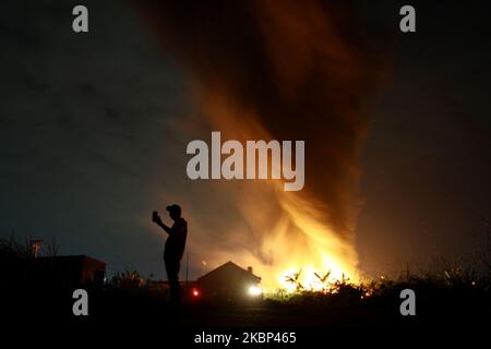 Die Bewohner beobachten die Flammen, wie am 21. Mai 2020 in der Kunststoff-Recycling-Fabrik in Bekasi, Provinz West-Java, Feuer ausbrach. Augenzeugenberichten zufolge kam es aufgrund eines elektrischen Kurzschlusses zu einem Brand, als die Fabrik aufgrund der Einführung einer groß angelegten sozialen Beschränkung im Zuge der Coronavirus-Covid-19-Krise geschlossen wurde. Im Präsidenten wurden keine Todesfälle gemeldet. (Foto von Aditya Irawan/NurPhoto) Stockfoto