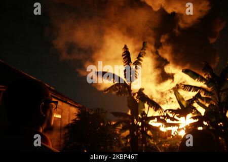 Die Bewohner beobachten die Flammen, wie am 21. Mai 2020 in der Kunststoff-Recycling-Fabrik in Bekasi, Provinz West-Java, Feuer ausbrach. Augenzeugenberichten zufolge kam es aufgrund eines elektrischen Kurzschlusses zu einem Brand, als die Fabrik aufgrund der Einführung einer groß angelegten sozialen Beschränkung im Zuge der Coronavirus-Covid-19-Krise geschlossen wurde. Im Präsidenten wurden keine Todesfälle gemeldet. (Foto von Aditya Irawan/NurPhoto) Stockfoto