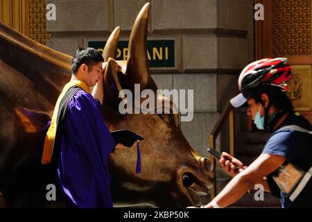 Ein Blick auf neue Absolventen, die während der Coronavirus-Pandemie am 20. Mai 2020 in Bowling Green, New York City, Fotos beim Charging Bull machen. COVID-19 hat sich in den meisten Ländern der Welt verbreitet und forderte über 316.000 Menschenleben mit über 4,8 Millionen gemeldeten Infektionen. (Foto von John Nacion/NurPhoto) Stockfoto