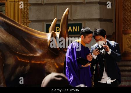 Ein Blick auf neue Absolventen, die während der Coronavirus-Pandemie am 20. Mai 2020 in Bowling Green, New York City, Fotos beim Charging Bull machen. COVID-19 hat sich in den meisten Ländern der Welt verbreitet und forderte über 316.000 Menschenleben mit über 4,8 Millionen gemeldeten Infektionen. (Foto von John Nacion/NurPhoto) Stockfoto