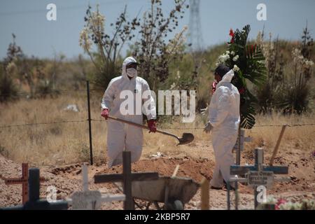 Friedhofsmitarbeiter begraben den Sarg mit den Überresten eines mutmaßlichen Opfers von COVID-19 in einem Gebiet des städtischen Pantheons von San Rafael, das den Opfern des neuartigen Coronavirus vorbehalten ist, am 21. Mai in Ciudad Juarez, Bundesstaat Chihuahua, Mexiko, 2020. (Foto von David Peinado/NurPhoto) Stockfoto