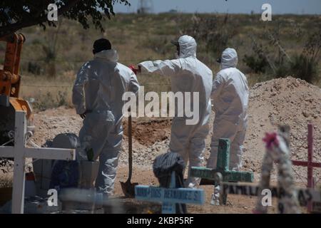 Friedhofsmitarbeiter begraben den Sarg mit den Überresten eines mutmaßlichen Opfers von COVID-19 in einem Gebiet des städtischen Pantheons von San Rafael, das den Opfern des neuartigen Coronavirus vorbehalten ist, am 21. Mai in Ciudad Juarez, Bundesstaat Chihuahua, Mexiko, 2020. (Foto von David Peinado/NurPhoto) Stockfoto