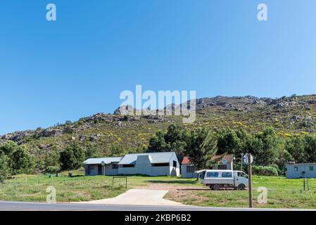 BAINSKLOOF PASS, SÜDAFRIKA - SEP 9, 2022: Bauernhäuser an der Straße R301 am nördlichen Beginn des Bainskloof Passes. Ein Fahrzeug ist sichtbar Stockfoto